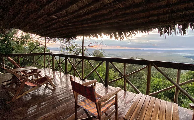 Holzterrasse mit Reetdach, atemberaubende Ausblicke von einem der Deluxe-Zelte in unserem Masai Mara Safari Camp